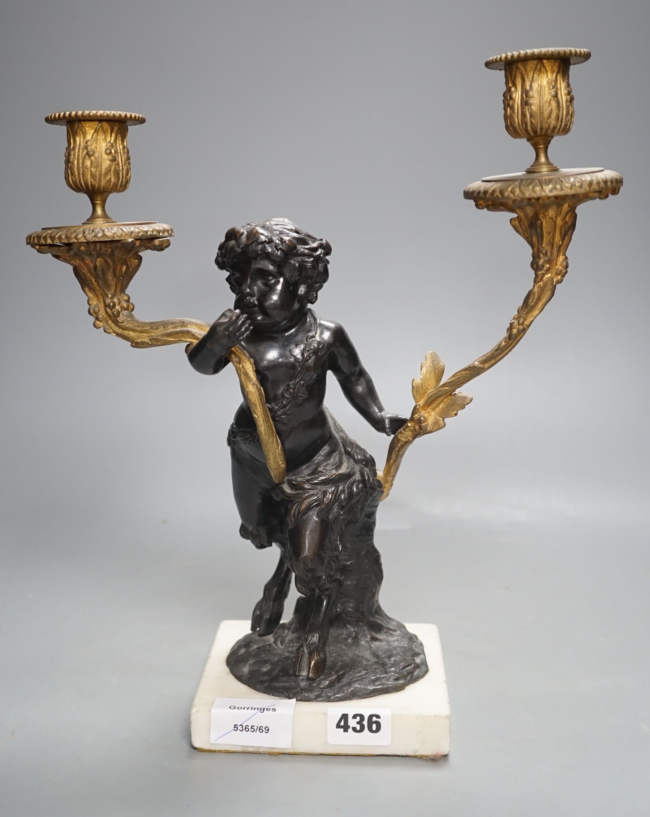 A bronze and ormolu putto two branch candelabrum, 33 cms high.